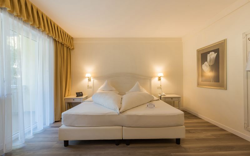 Camera doppia luminosa con balcone e vista sulle montagne dell'hotel Funggashof in Alto Adige